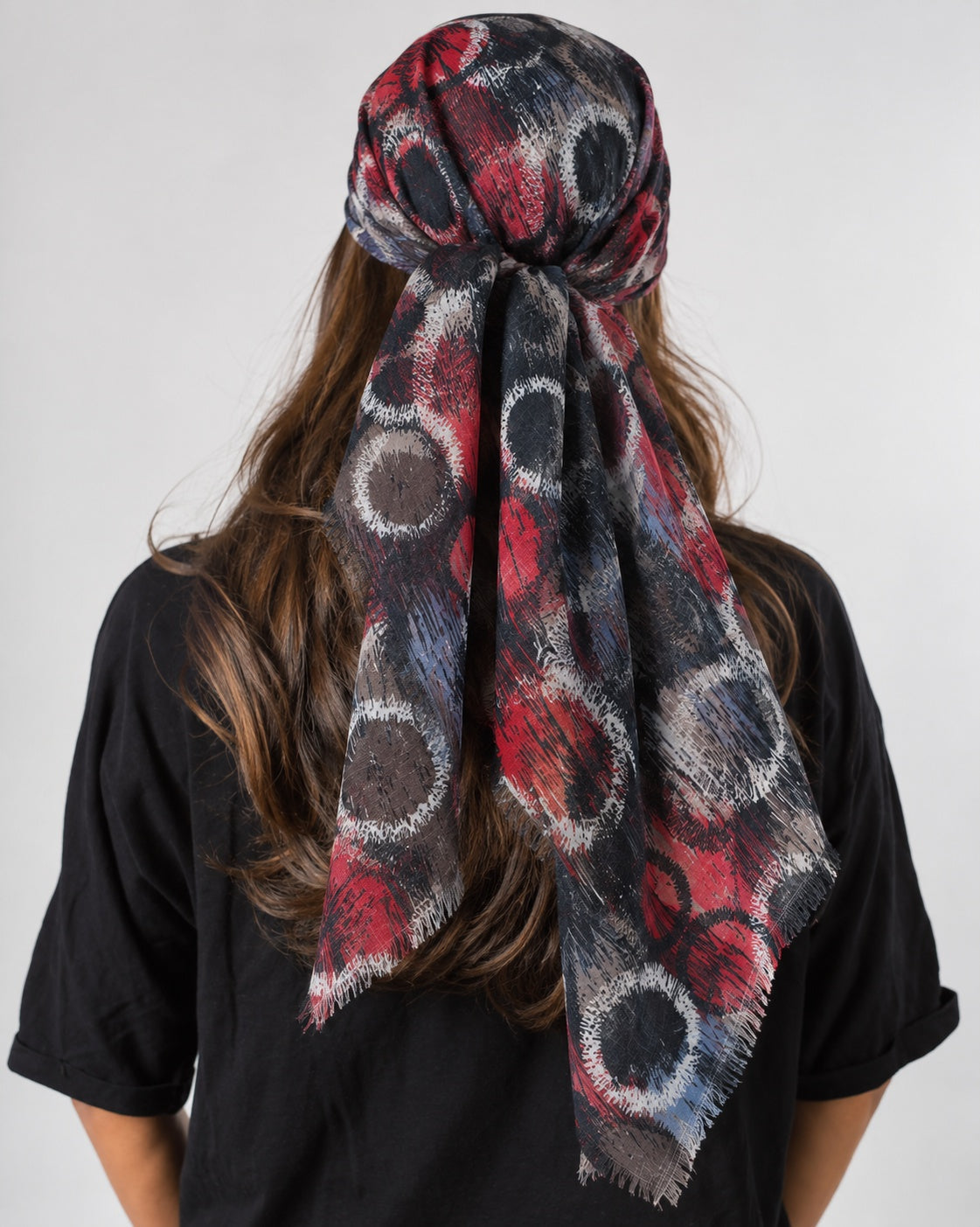 Collected NYC abstract circle print headscarf in burgundy, plum, and grey with frayed edges worn as a head wrap